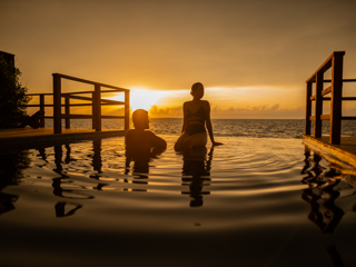 Pareja de personas dentro de una piscina en hotel en Barú mirando el horizonte